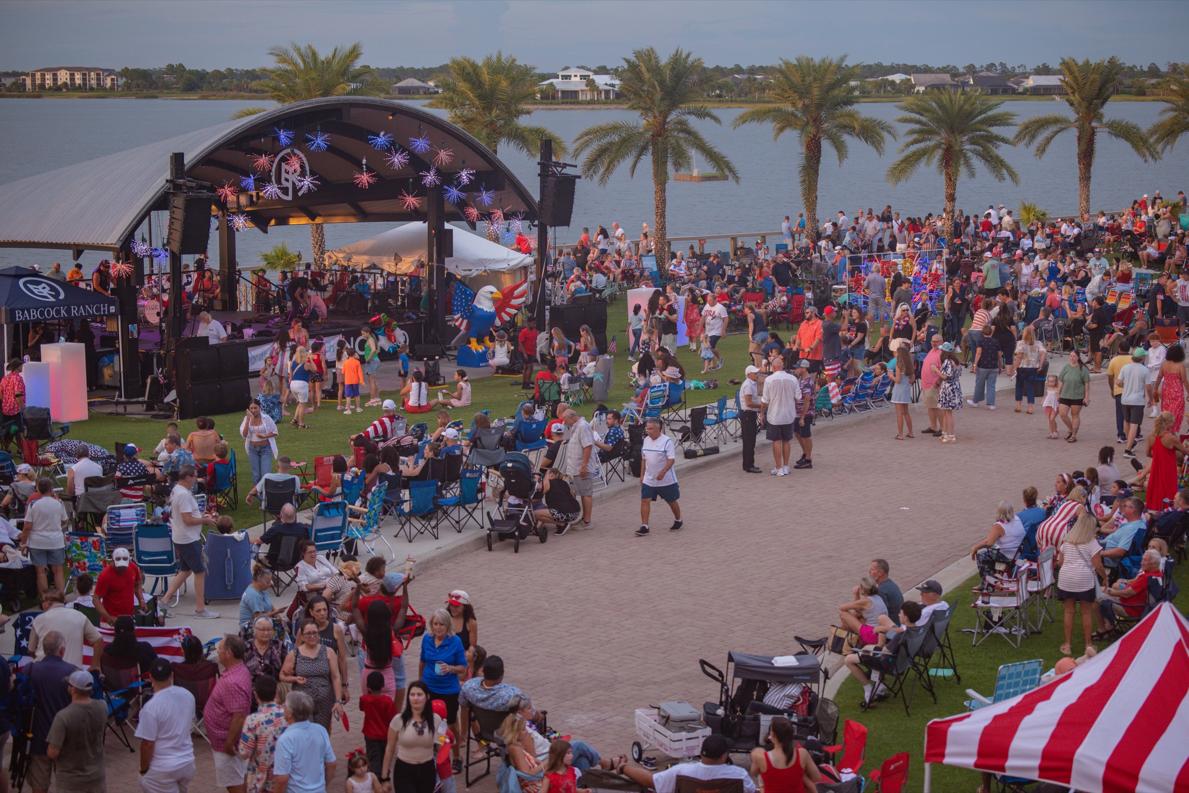 Community crowd beside the lakeside stage at Babcock Ranch during a past Fourth of July event