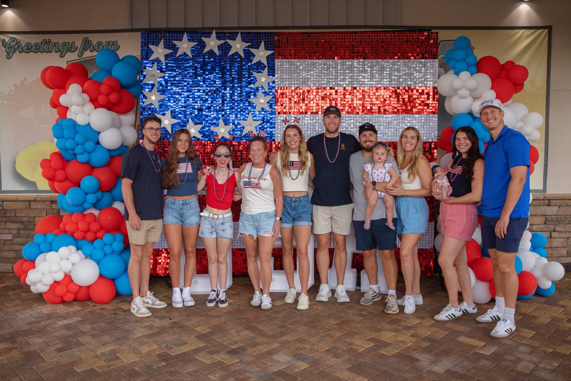 Guests posing in front of an American flag backdrop at Babcock Ranch’s 2025 Fourth of July celebration