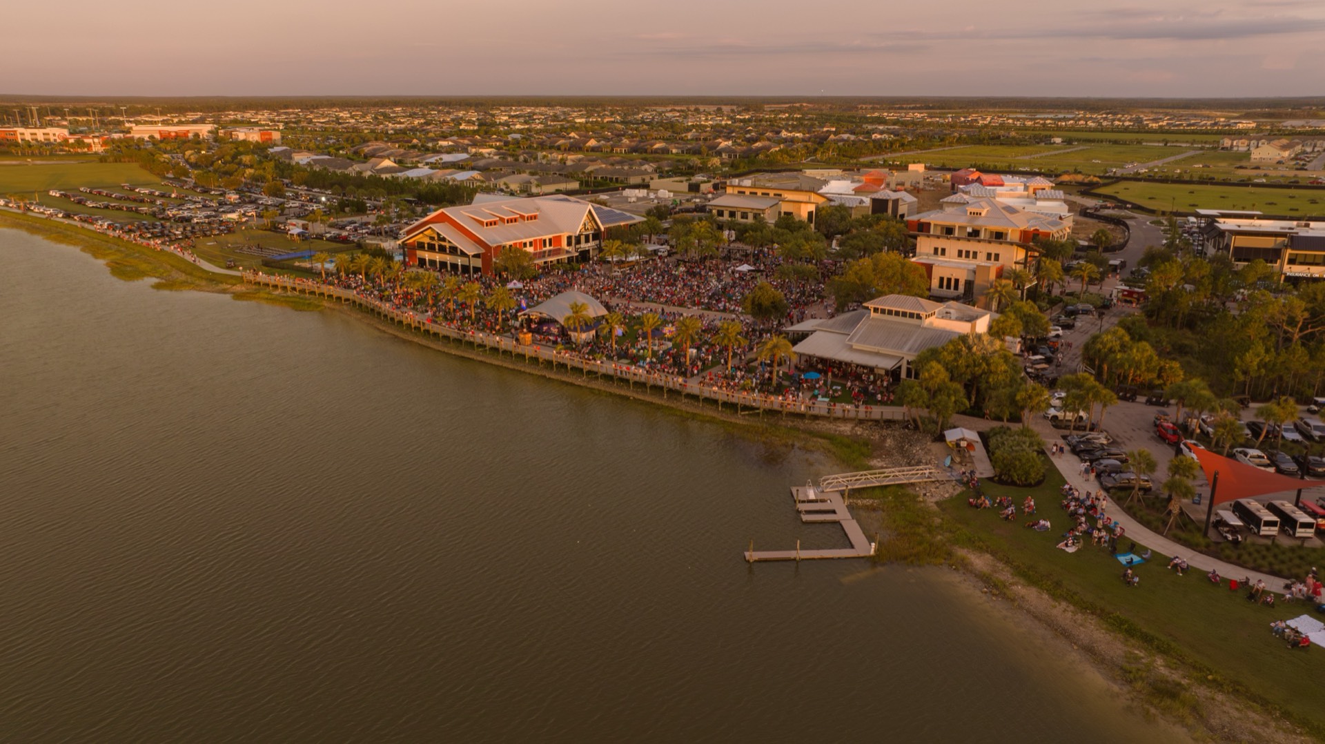Evening aerial view of Founders Square, the lakefront and a large crowd at Babcock Ranch’s 2026 Fourth of July celebration